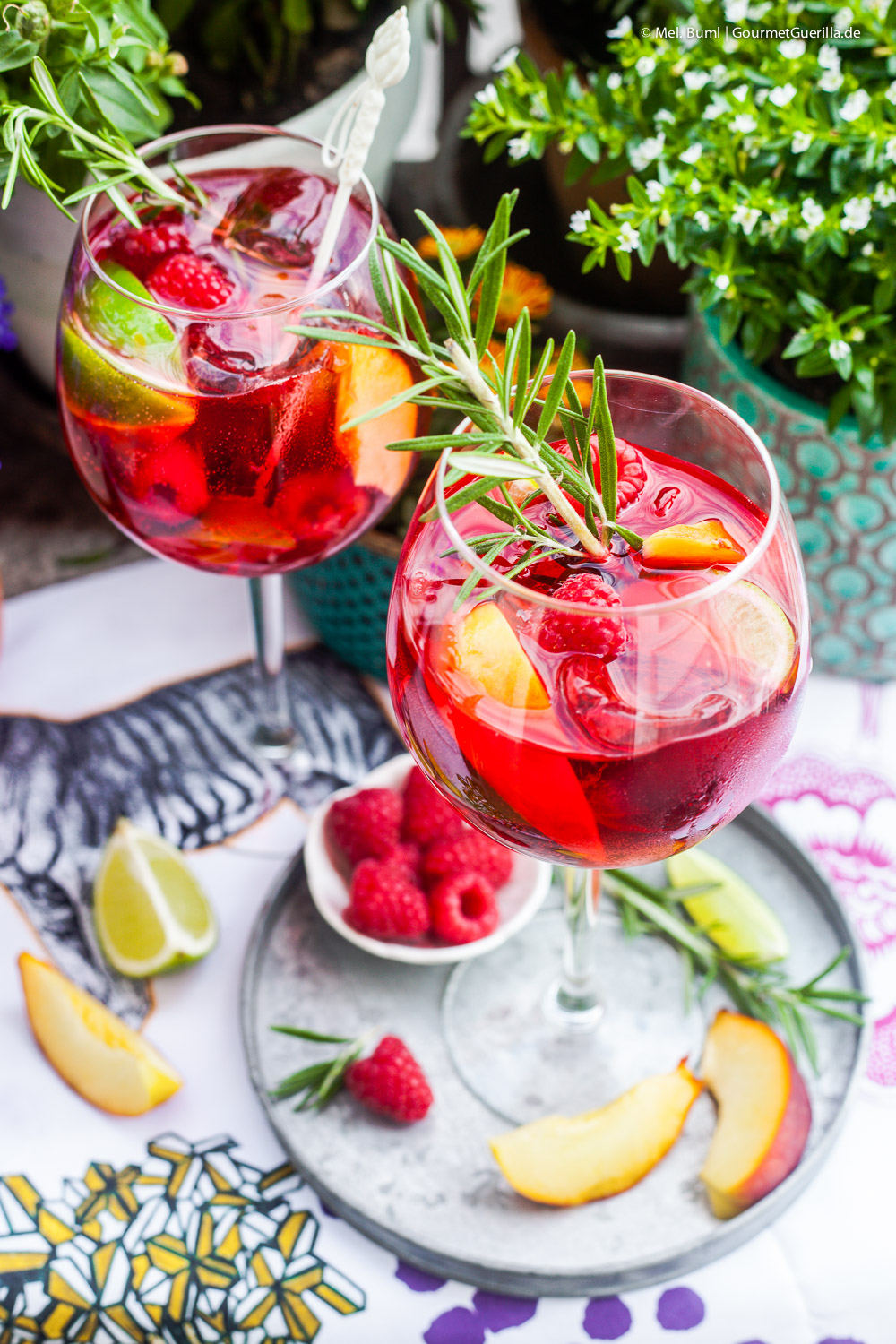Hibiscus infused raspberry secco punch with peaches and rosemary. A summer punch in a glass.
